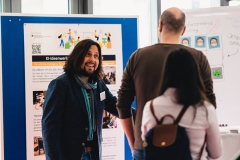 Dr. Stefan Ulrich im Gespräch mit einem Teilnehmeden am Stand der KI Ideenwerkstatt auf dem 2. Forum des NMZB.