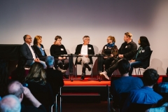 Die Teilnehmenden der Podiumsdiskussion im Gespräch sitzend im Halbkreis.