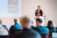 Dr. Christina Lachmann stands at the speakers desk and presents the results from her workshop.