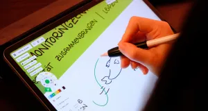 Großaufnahme einer Hand, die auf einen Tablet zeichnet. So sollen Inhalte eines Vortrags bildhaft festgehalten werden.