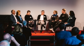 Die Teilnehmenden der Podiumsdiskussion im Gespräch sitzend im Halbkreis.