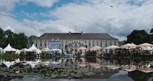 Hauptbühne der Woche der Umwelt vor dem Schloss Bellevue, im Vordergrund spiegelt sich die Szene im Teich, der mit Seerosen bedeckt ist 