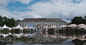 Hauptbühne der Woche der Umwelt vor dem Schloss Bellevue, im Vordergrund spiegelt sich die Szene im Teich, der mit Seerosen bedeckt ist 
