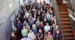 Eine große Gruppe von Menschen steht im Foyer und blickt nach oben