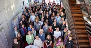 Eine große Gruppe von Menschen steht im Foyer und blickt nach oben