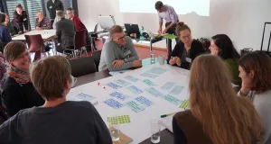 Eine Gruppe von Menschen sitzt um einen Tisch und diskutiert