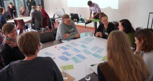 Eine Gruppe von Menschen sitzt um einen Tisch und diskutiert