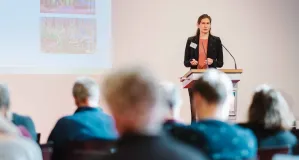 Dr. Christina Lachmann stands at the speakers desk and presents the results from her workshop.