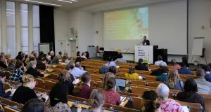 Ein Mann steht am Podium und hält einen Vortrag in einem Hörsaal