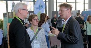 Eine Frau und zwei Männer stehen zusammen und unterhalten sich