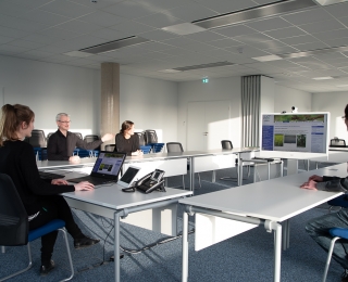 Several people sitting at a table in a meeting room