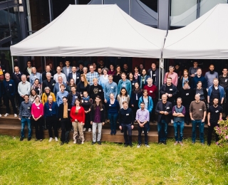 Gruppenbild der Teilnehmenden des 2. Forums des Monitoringzentrums im Hof des Mediencampus Villa Ida in Leipzig.