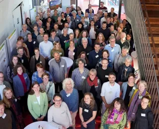Eine große Gruppe von Menschen steht im Foyer und blickt nach oben